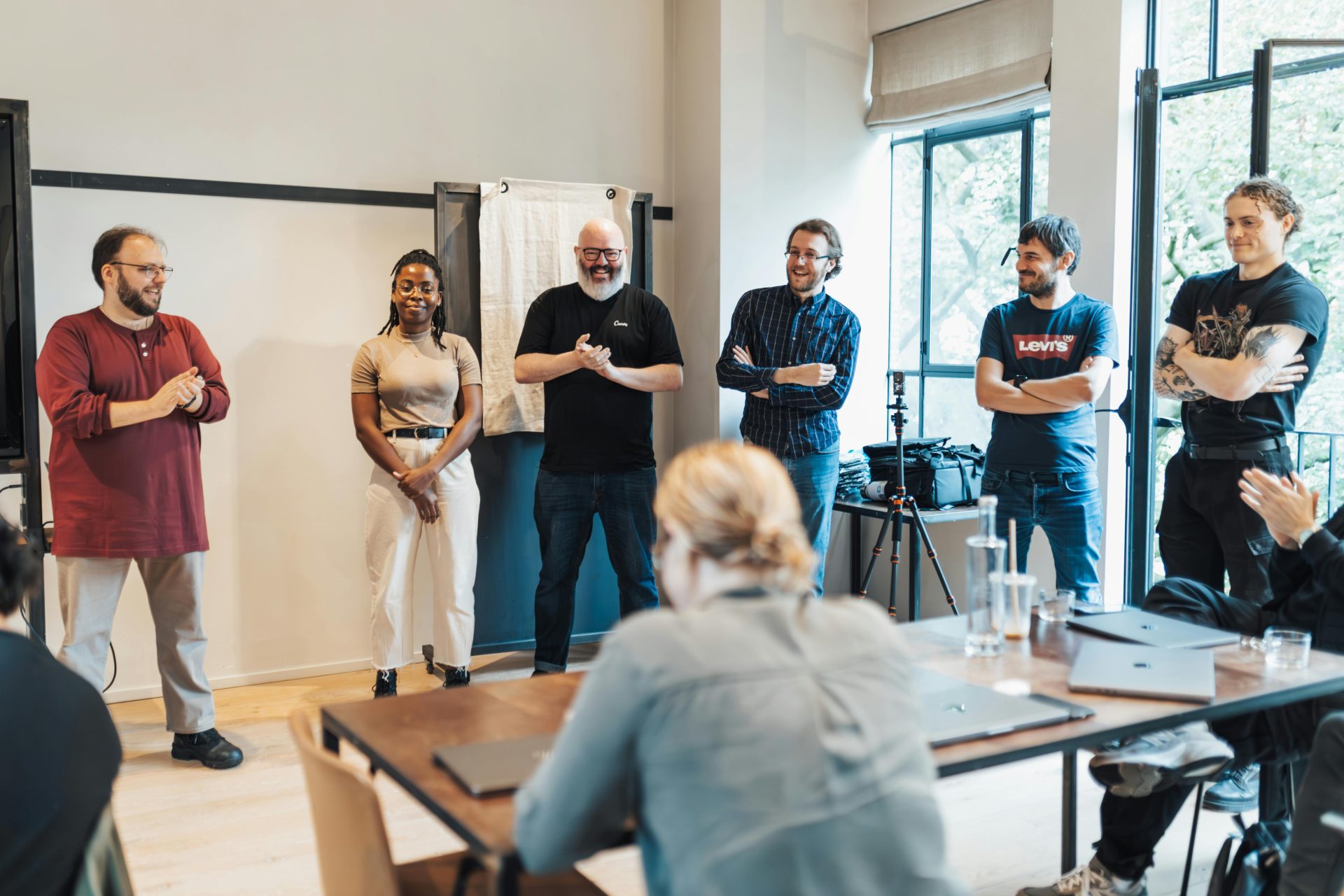 A diverse group of adults engaging in a casual team meeting indoors.