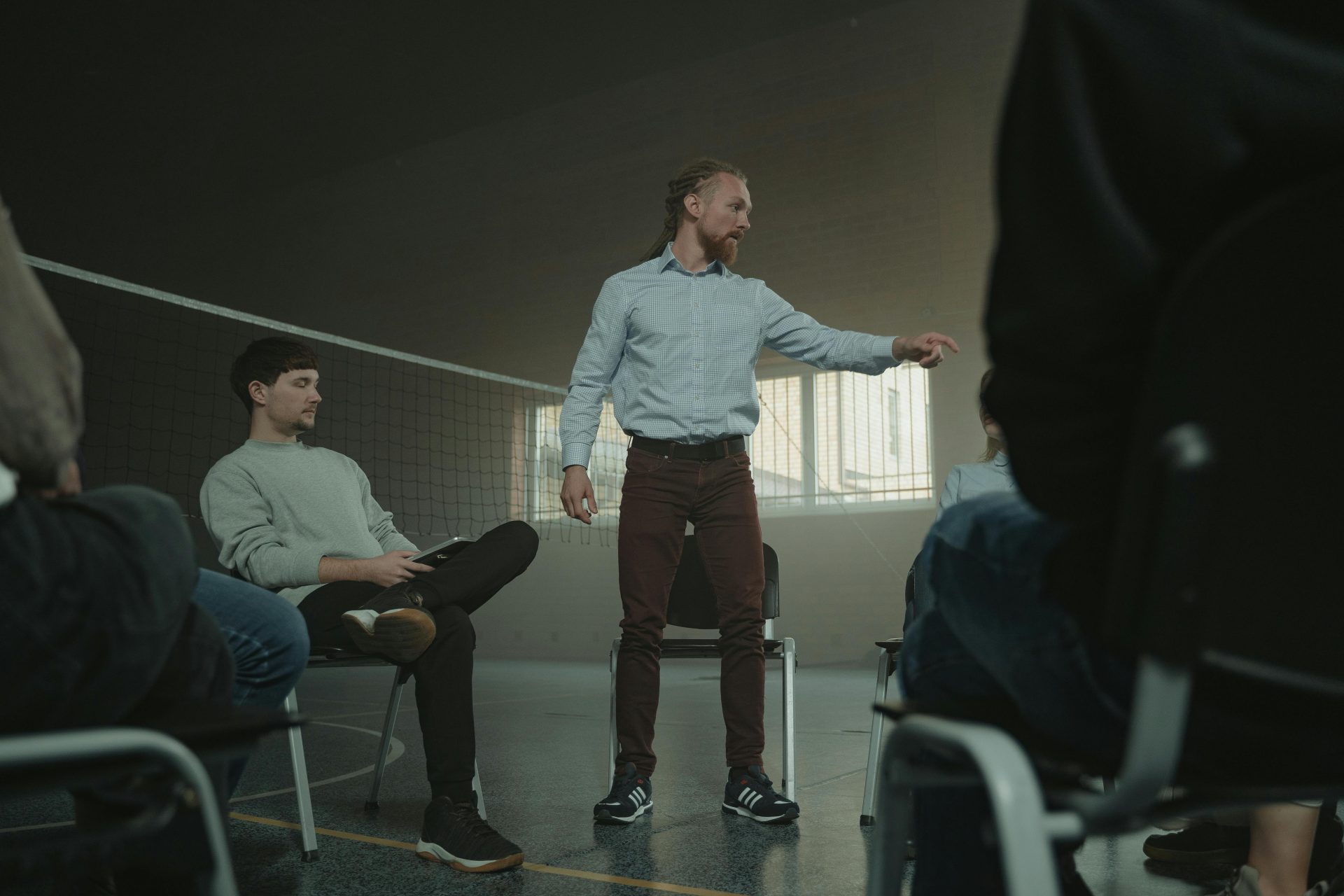 A group therapy session indoors with diverse adults engaging in discussion and support.